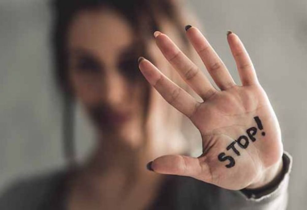 Sexual Abuse Woman raises hand with "stop" written on it