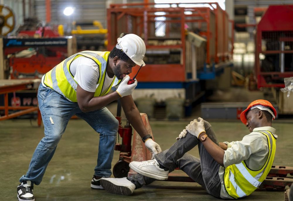 Injured Workers A worker in a safety vest assists a colleague