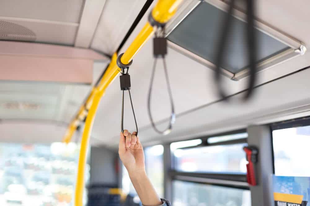 Hand of a Person Inside a Bus Holding on to the Bus Straps