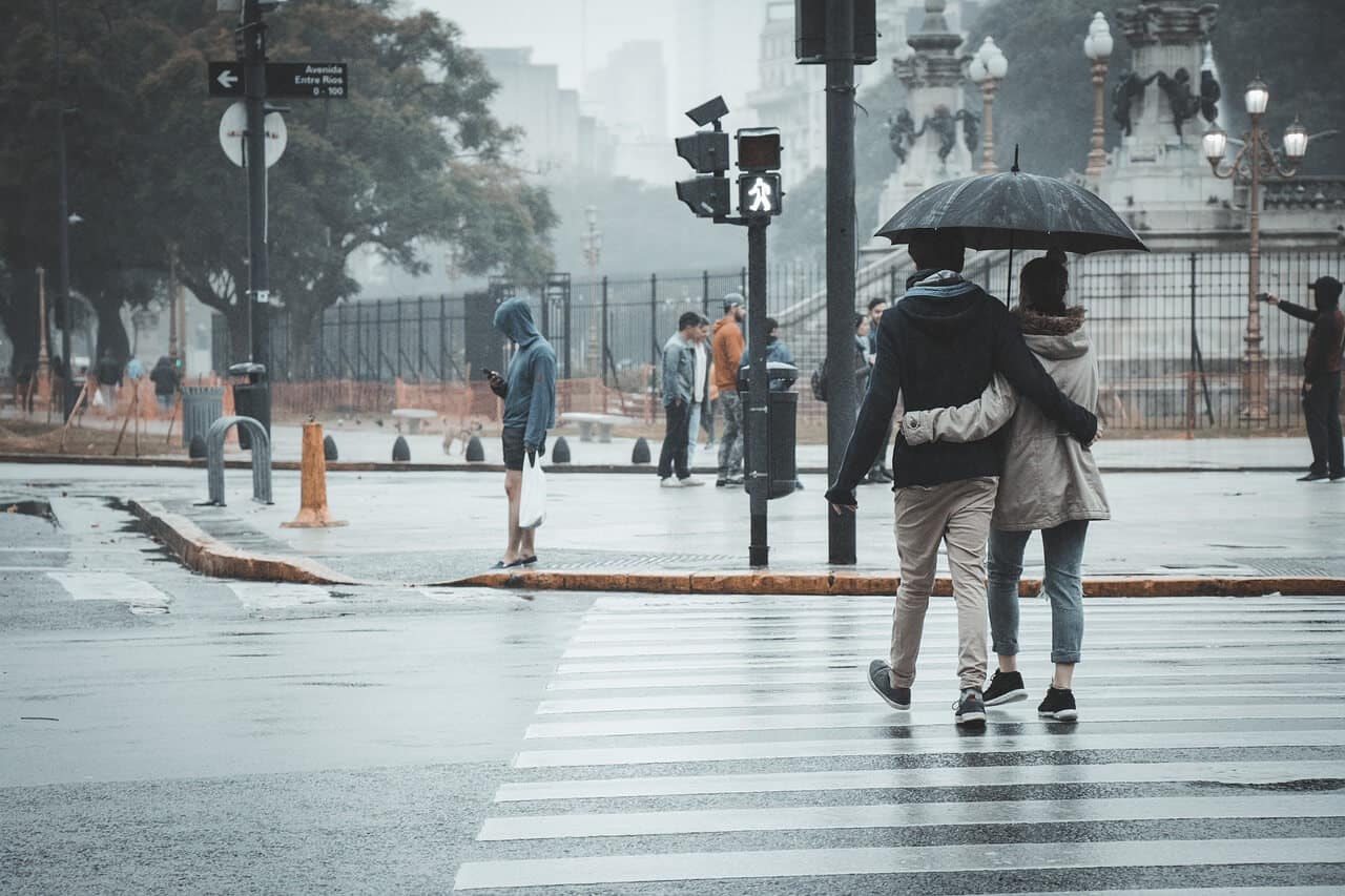 A Couple Walking on a Crosswalk in the Rain