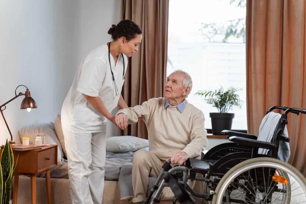 Nurse Helping Elder Patient to His Wheelchair