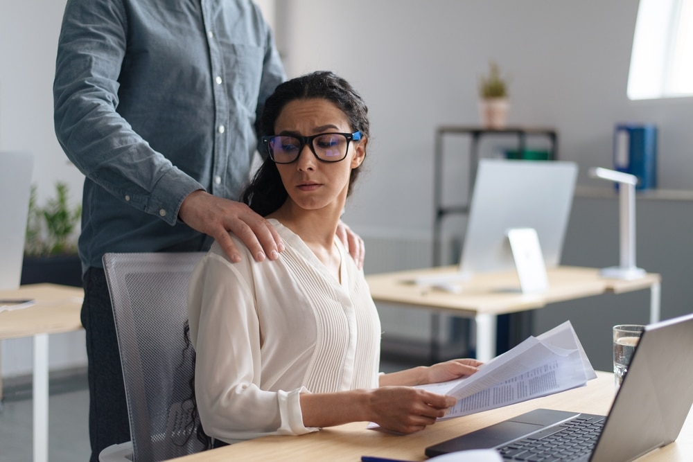 Abuse at Work Photo of a man touching woman's shoulders
