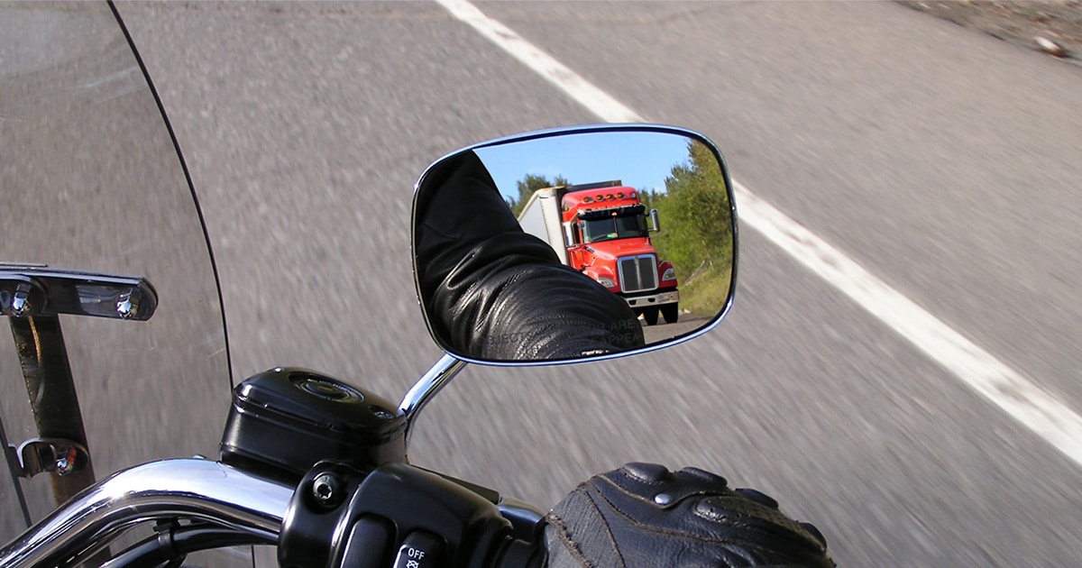 Motorcycle on the Road and a Truck Visible on the Mirrors