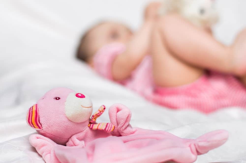 Baby Playing Pink Teddy Bear Next To A Baby