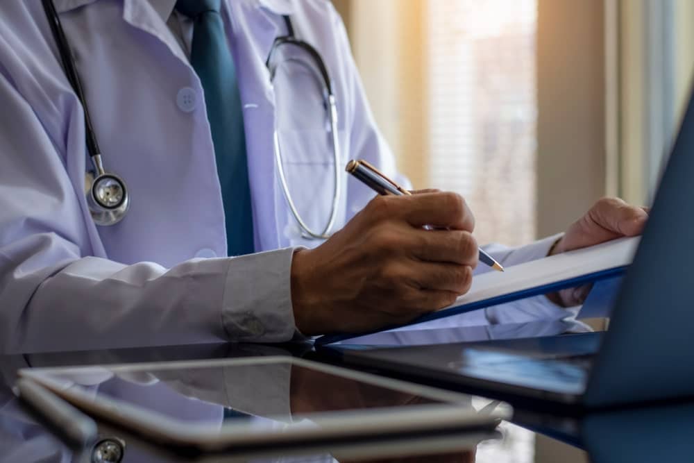 Doctor Filling Out Medical Papers