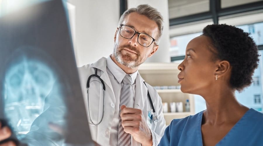 A man in glasses looking at x-ray
