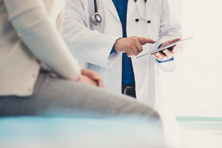 Photo of a doctor pointing finger at the tablet 